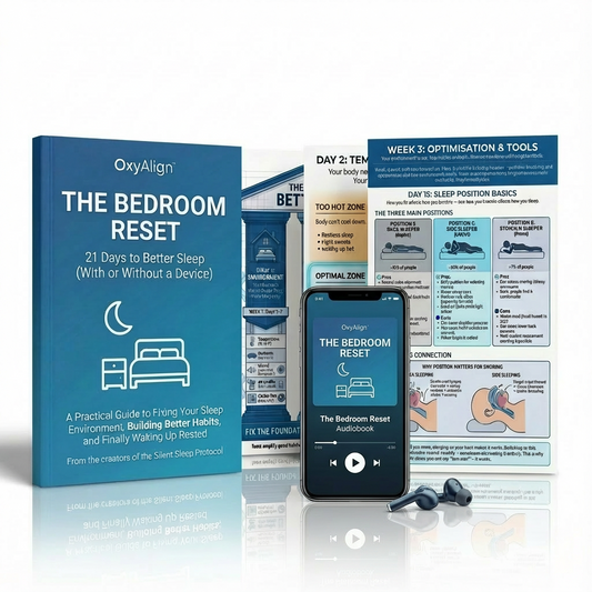 OxyAlign 'The Bedroom Reset' book, smartphone with audiobook app, and earbuds on a reflective surface.